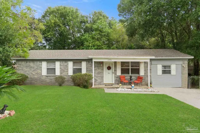 a view of a house with a backyard and sitting area