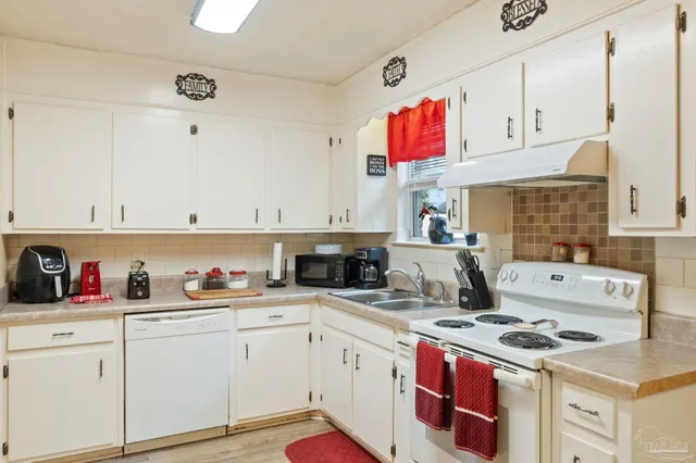 a kitchen with cabinets a stove and a sink