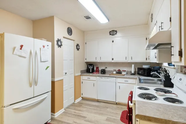 a kitchen with stainless steel appliances a sink a refrigerator and cabinets