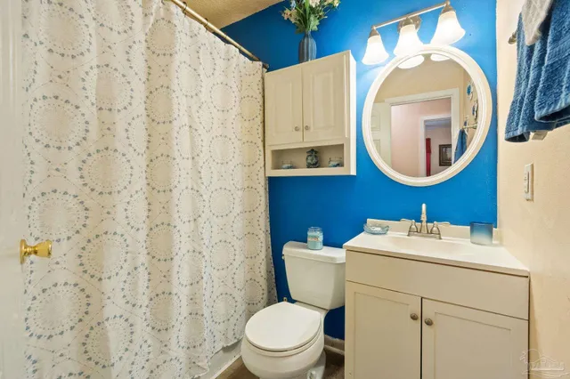 a bathroom with a sink mirror vanity and toilet