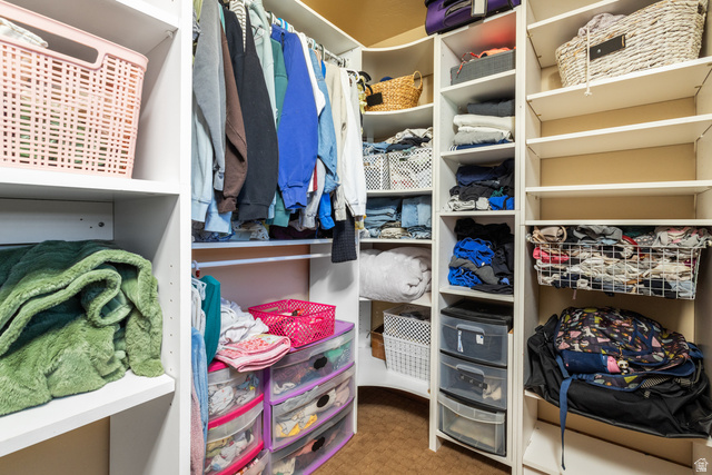 892 Cambridge Drive St. George, UT 84770 - Photo 42 of 65 Walk-in closet featuring extensive built-in shelving, multiple hanging rods, and corner storage solutions