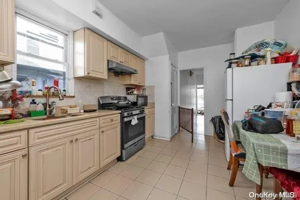 a kitchen with stainless steel appliances a stove a sink cabinets and a dining table