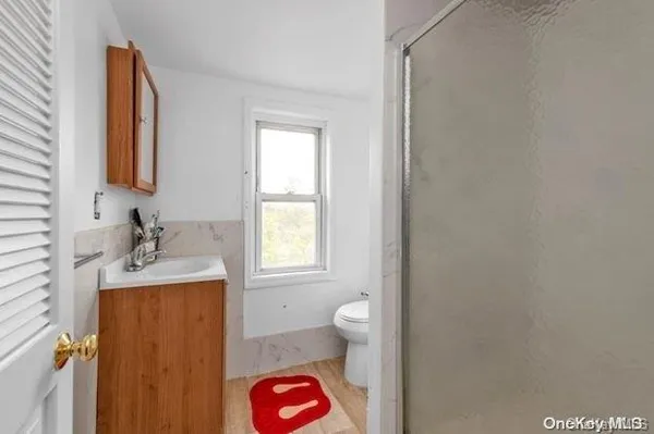 a bathroom with a sink a toilet and a window