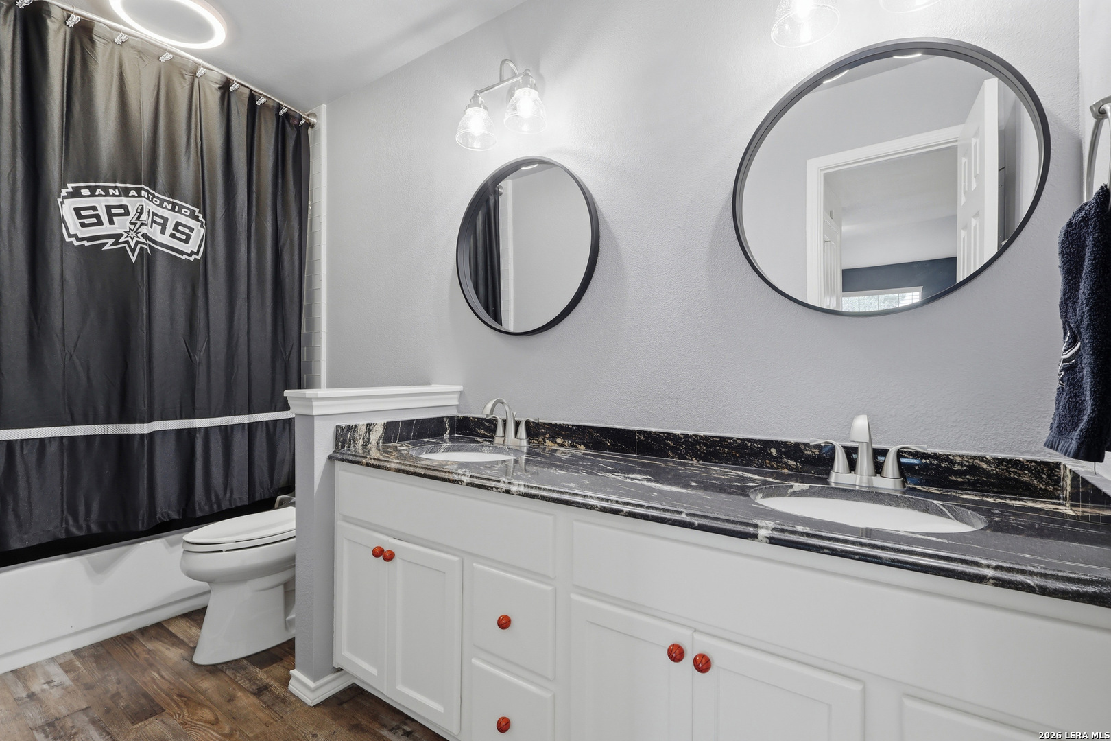 12703 Holly Cedar Helotes, TX 78023 - Photo 16 of 23 a bathroom with a granite countertop toilet a sink and a mirror