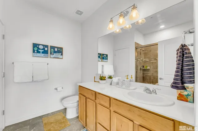 a bathroom with a sink a toilet and a large mirror