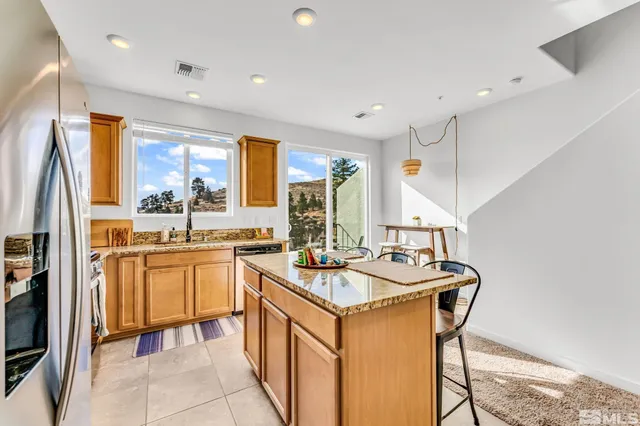 a kitchen with stainless steel appliances granite countertop a sink and a refrigerator