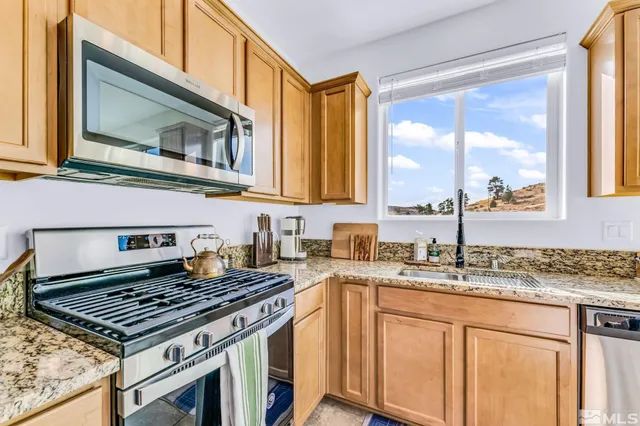 a kitchen with stainless steel appliances granite countertop a sink stove and microwave