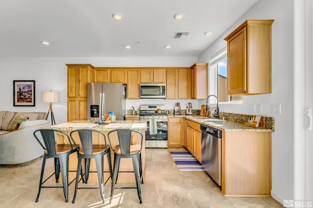 a kitchen with appliances a sink a counter top space and a window