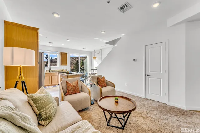 a living room with furniture a rug and kitchen view