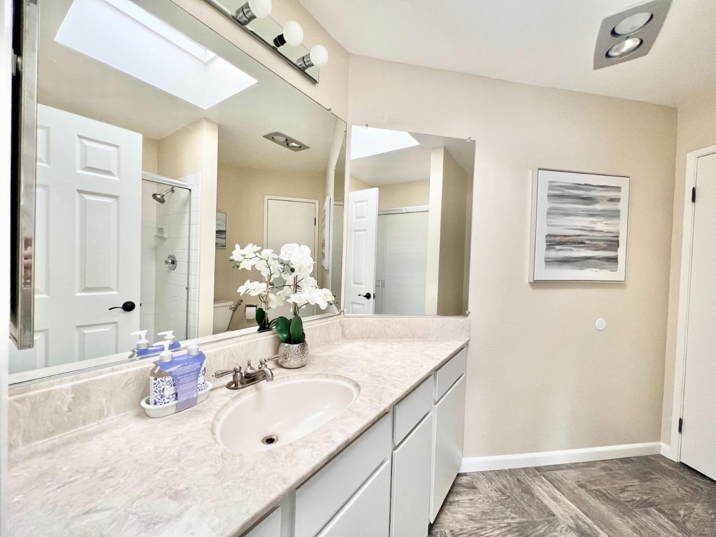 834 Wharfside Road San Mateo, CA 94404 - Photo 22 of 36 a bathroom with a granite countertop sink and a mirror