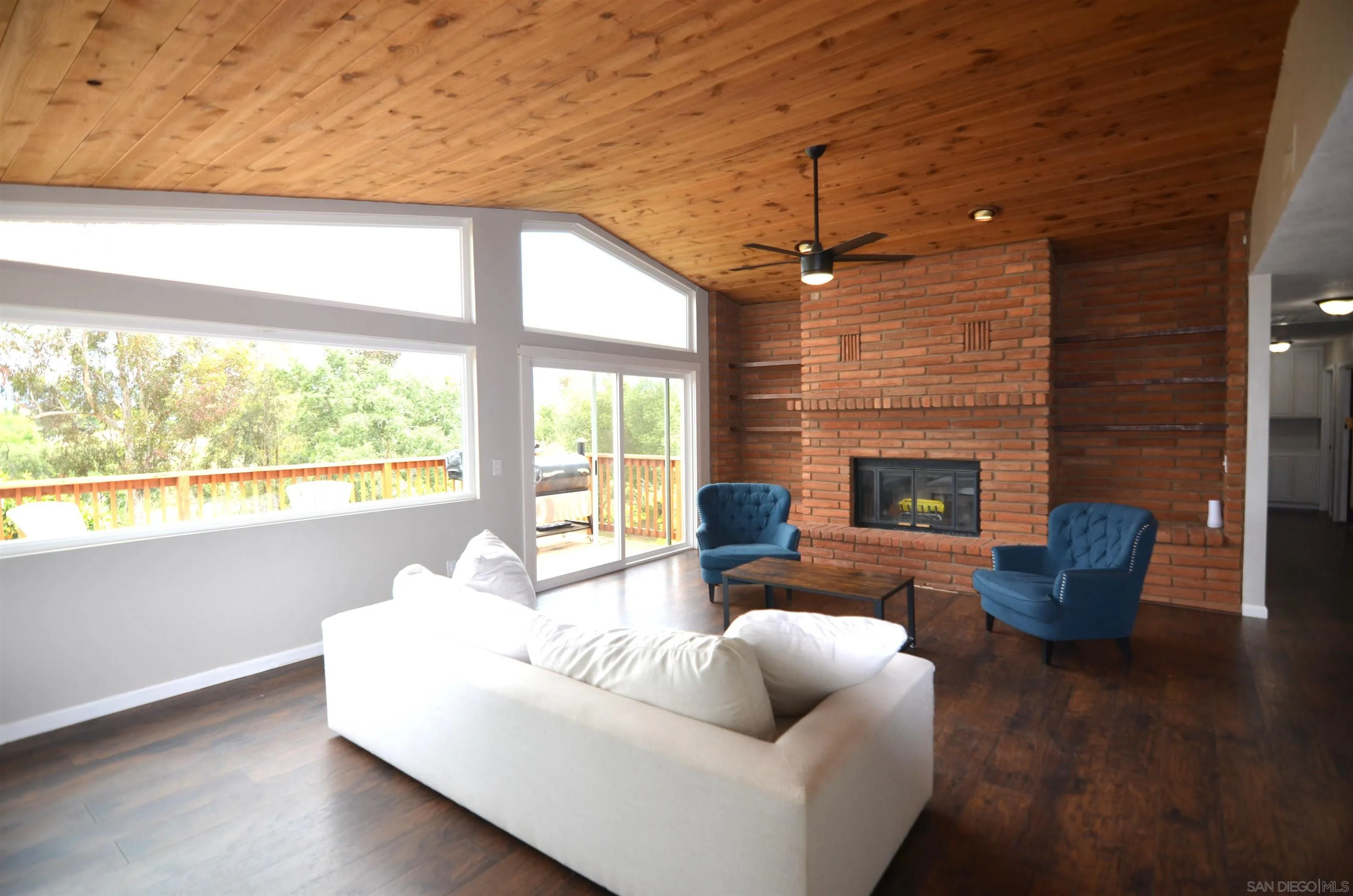 30643 Rabbit Run Valley Center, CA 92082 - Photo 12 of 59 a living room with furniture a fireplace and a floor to ceiling window