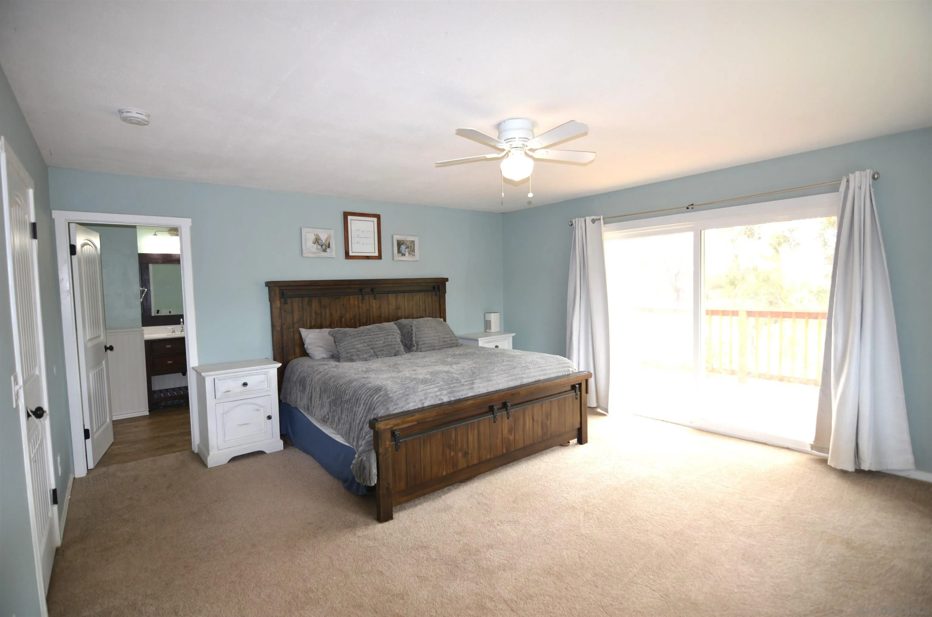 30643 Rabbit Run Valley Center, CA 92082 - Photo 23 of 59 a spacious bedroom with a bed and a window