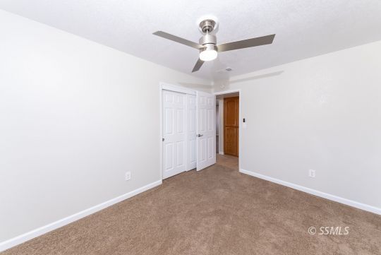 318 Reese Street Ridgecrest, CA 93555 - Photo 12 of 34 an empty room with a ceiling fan and a window