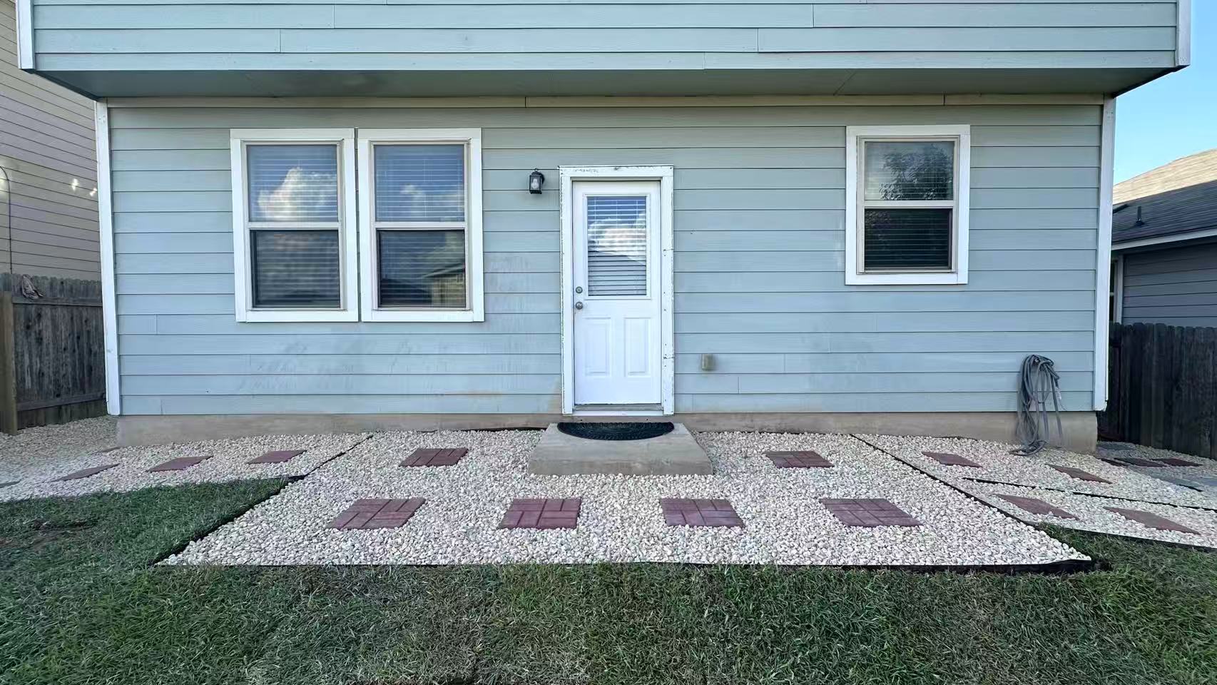 251 Triumph Road Buda, TX 78610 - Photo 24 of 26 An inviting backyard patio features white gravel with brick stepping stones, perfect for outdoor relaxation.