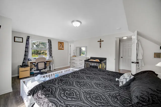 a bedroom with a bed and wooden floor