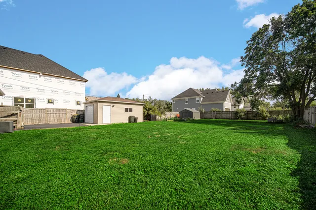 a view of a house with a yard and sitting area