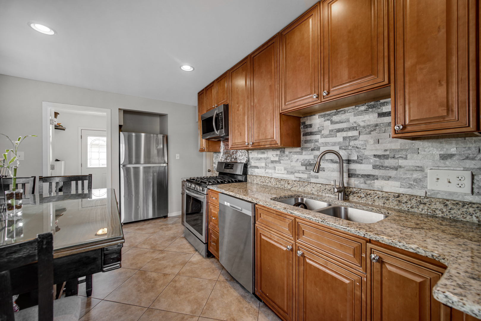 25W277 Doris Avenue Carol Stream, IL 60188 - Photo 8 of 27 a kitchen with stainless steel appliances granite countertop wooden cabinets a sink and dishwasher
