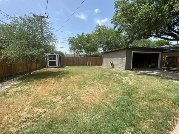 a front view of house with yard and trees in the background