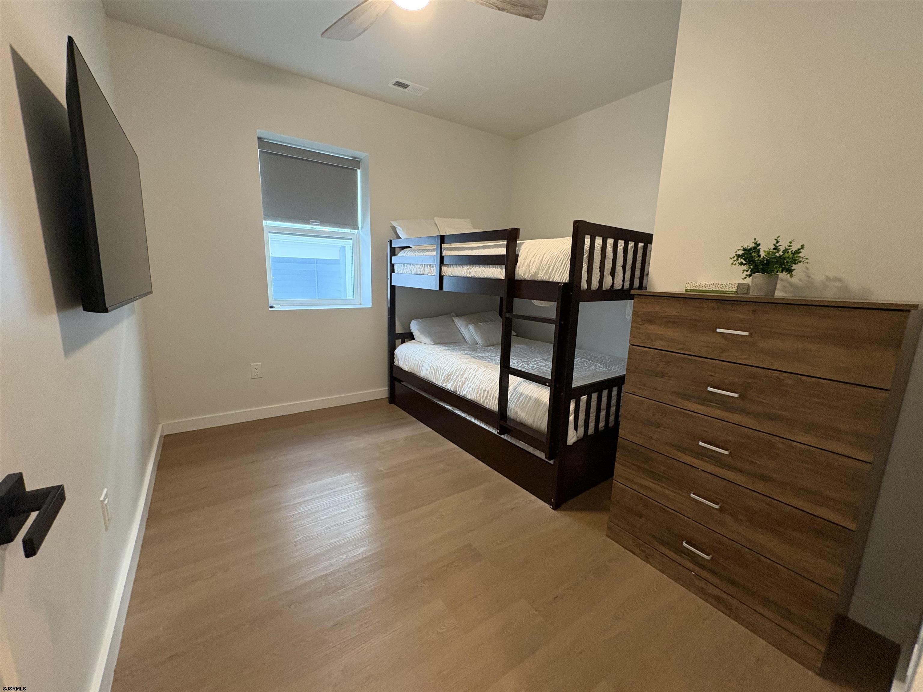 713 East 8th Street, Unit B Ocean City, NJ 08226 - Photo 9 of 25 a bedroom with a bed and flat screen tv