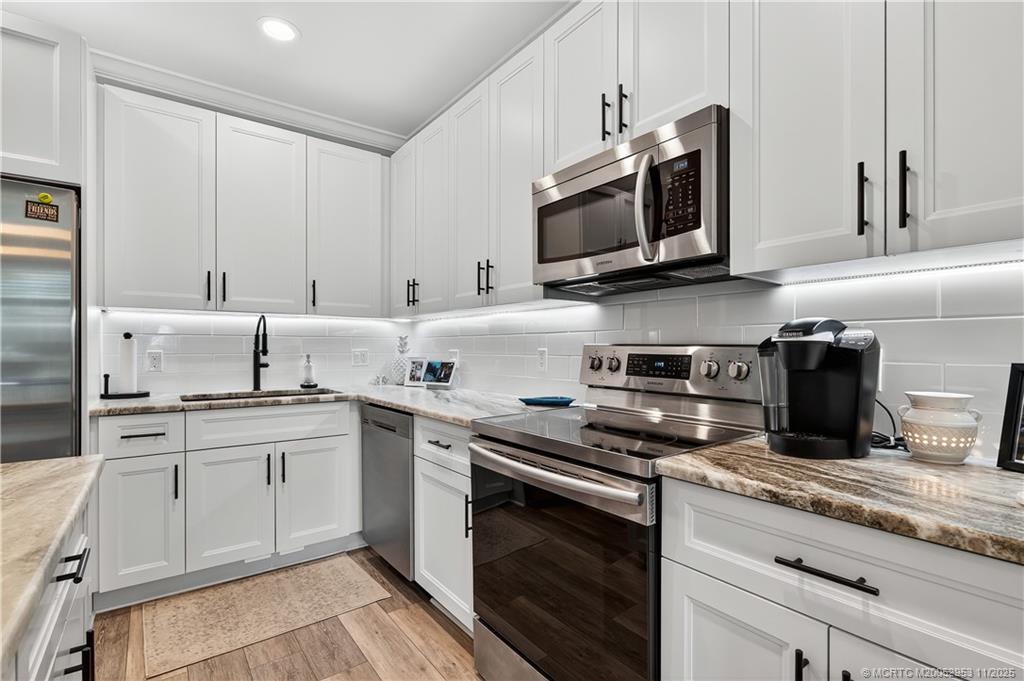 12463 Harbour Ridge Boulevard, Unit 26 Palm City, FL 34990 - Photo 11 of 34 a kitchen with appliances a sink and cabinets