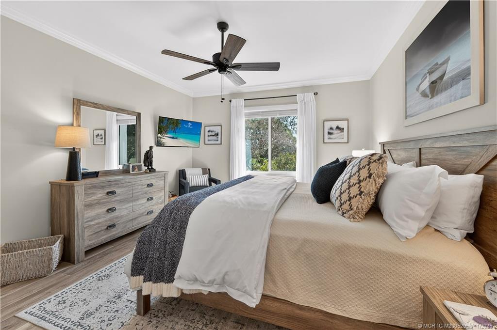 12463 Harbour Ridge Boulevard, Unit 26 Palm City, FL 34990 - Photo 15 of 34 a bedroom with a bed and a chandelier