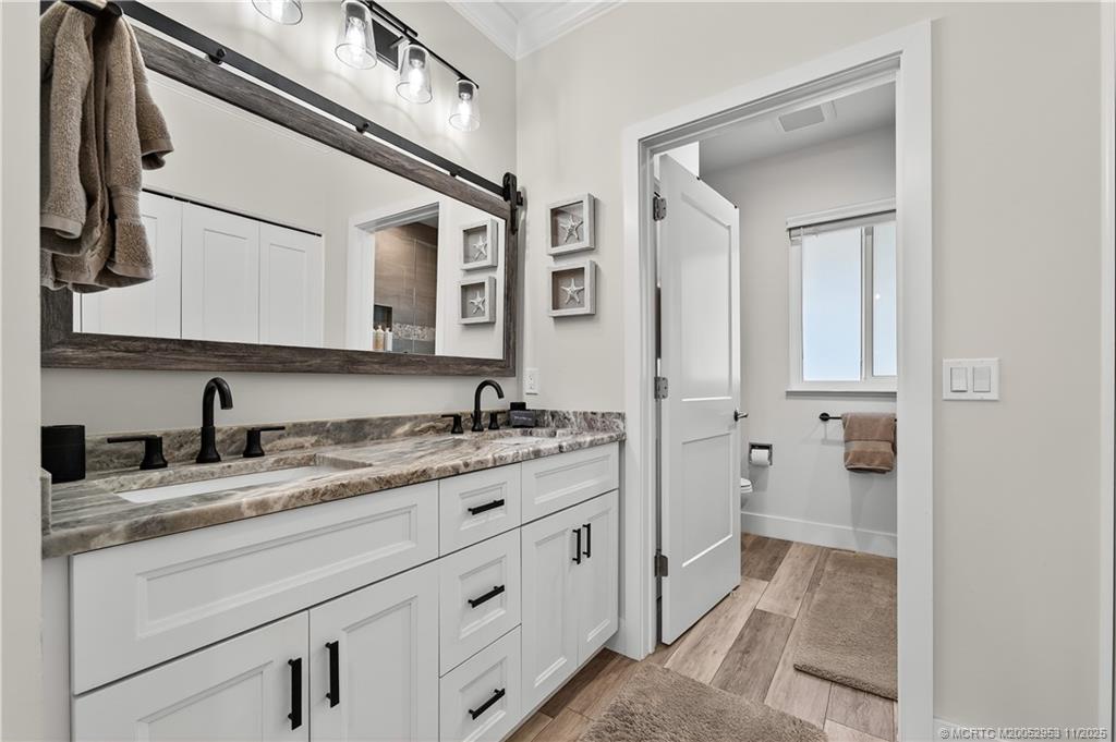 12463 Harbour Ridge Boulevard, Unit 26 Palm City, FL 34990 - Photo 17 of 34 a bathroom with a granite countertop sink and a mirror