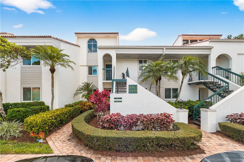 12463 Harbour Ridge Boulevard, Unit 26 Palm City, FL 34990 - Photo 2 of 34 a front view of a house with a garden