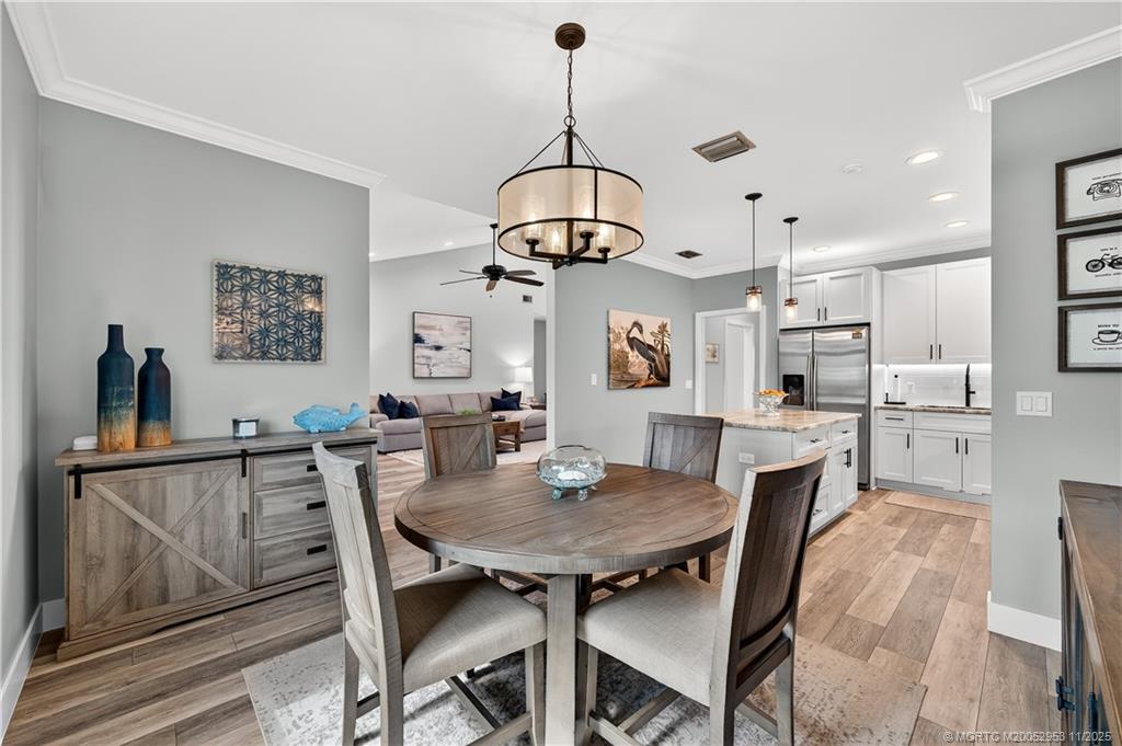 12463 Harbour Ridge Boulevard, Unit 26 Palm City, FL 34990 - Photo 9 of 34 a view of a dining room with furniture and wooden floor