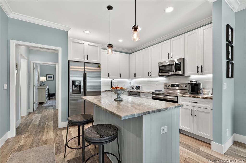 12463 Harbour Ridge Boulevard, Unit 26 Palm City, FL 34990 - Photo 10 of 34 a kitchen with kitchen island granite countertop a sink center island stainless steel appliances and cabinets