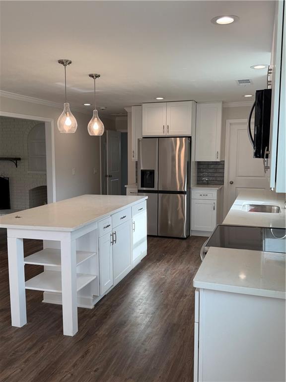 a kitchen with white cabinets and stainless steel appliances