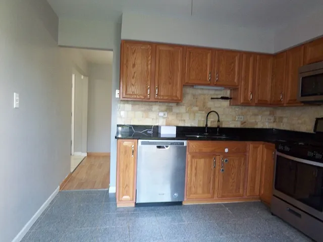 a kitchen with stainless steel appliances granite countertop a stove a sink and a refrigerator