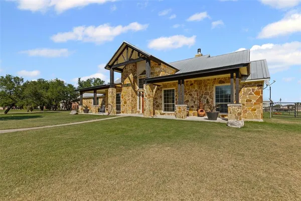a view of a house with a yard and sitting area