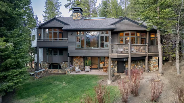 a view of a big house with table and chairs under an umbrella
