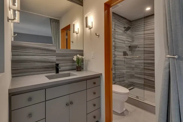 a bathroom with a sink a toilet and shower