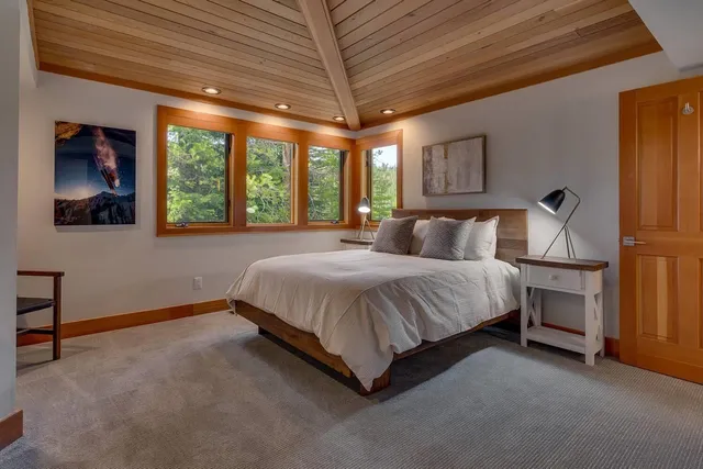 a spacious bedroom with a bed and a chandelier