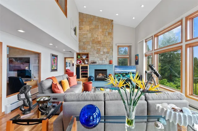 a living room with furniture a fireplace and a large window