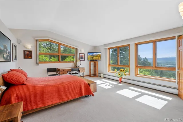a bedroom with furniture and large windows