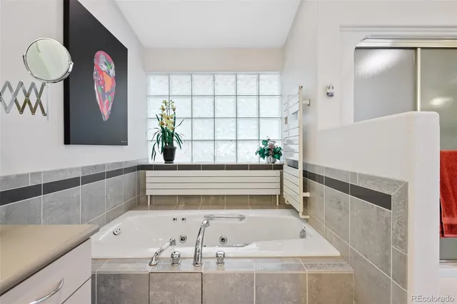 a bathroom with a tub and a large window