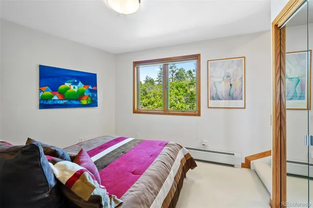 a bedroom with a bed and a painting on the wall