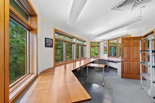 a view of a living room with furniture and large windows