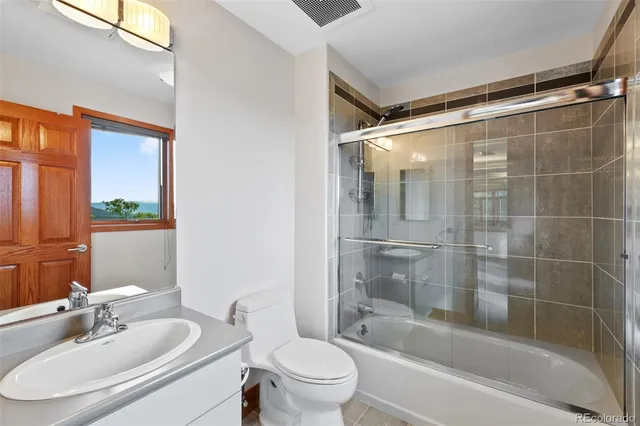 a bathroom with a bathtub shower sink vanity and toilet