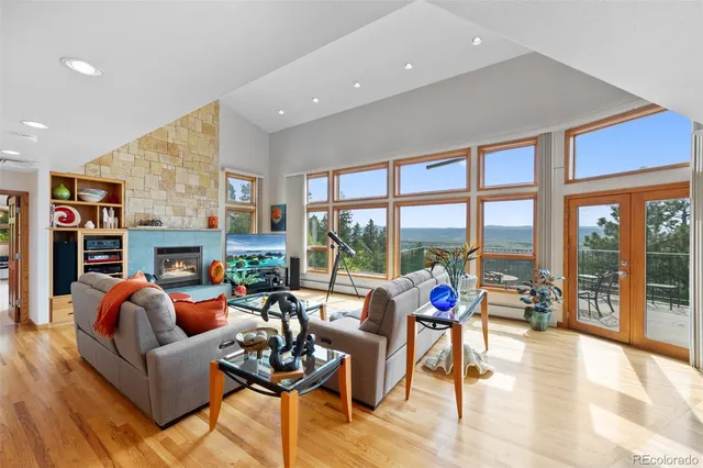 a living room with fireplace furniture and a large window