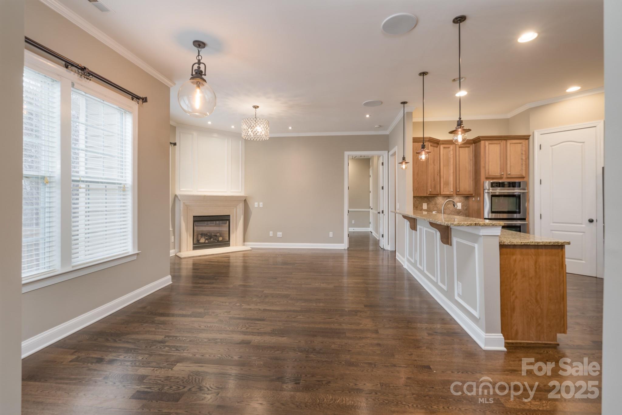 507 Quicksilver Trail Fort Mill, SC 29708 - Photo 9 of 48 a view of kitchen with kitchen island granite countertop a stove a sink a refrigerator and white cabinets with wooden floor