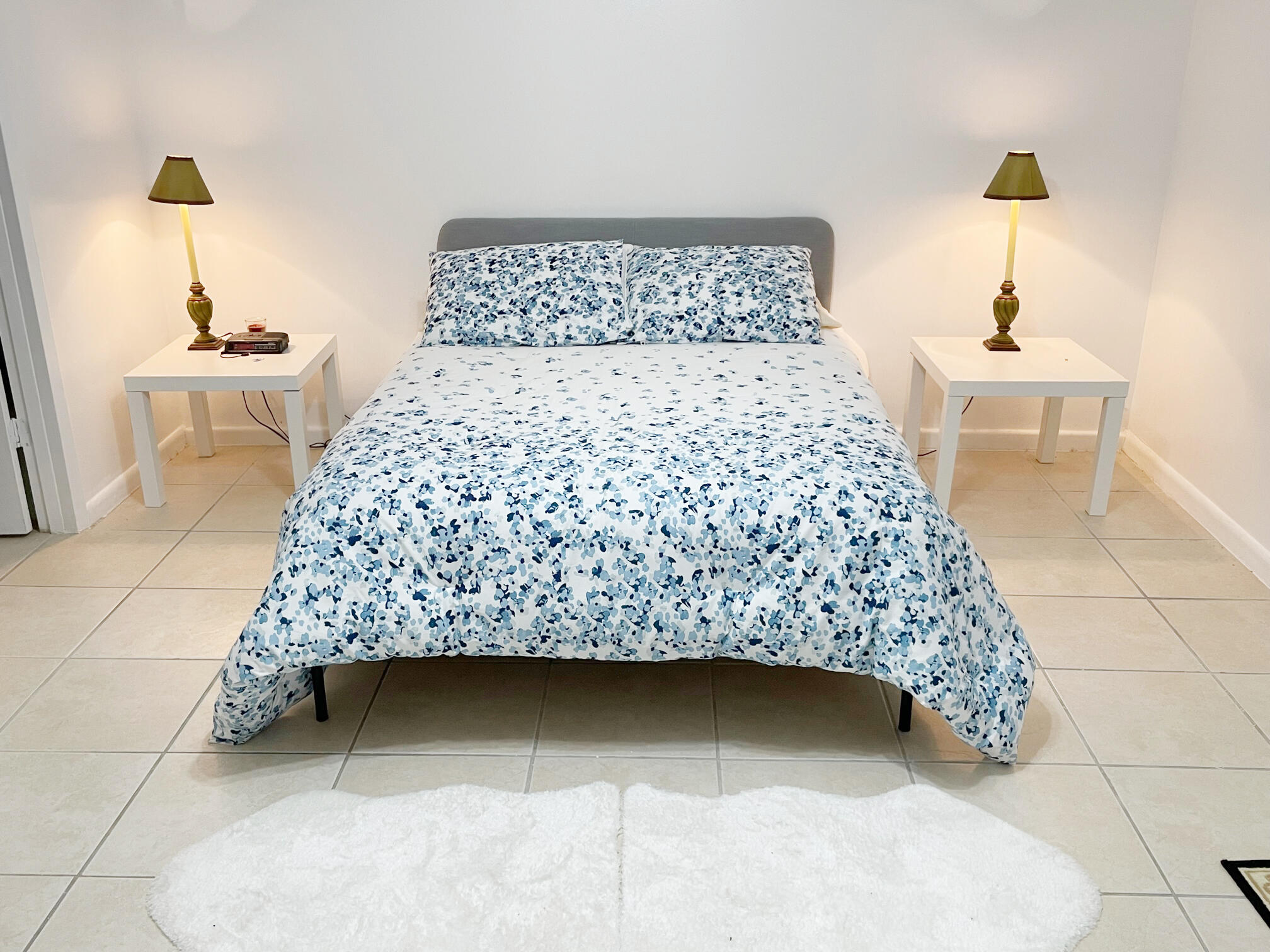 171 Suffolk F, Unit 171 Boca Raton, FL 33434 - Photo 15 of 21 a bed sitting in a bedroom next to a lamp and a chandelier