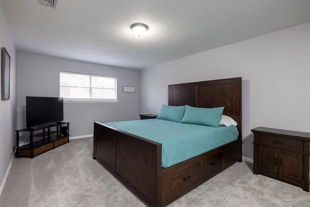 a bedroom with a bed and a flat screen tv