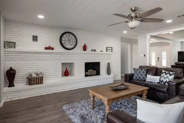 a living room with furniture a clock and a fireplace
