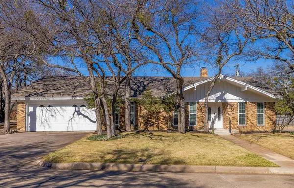 a patio with a yard table and chairs under an umbrella