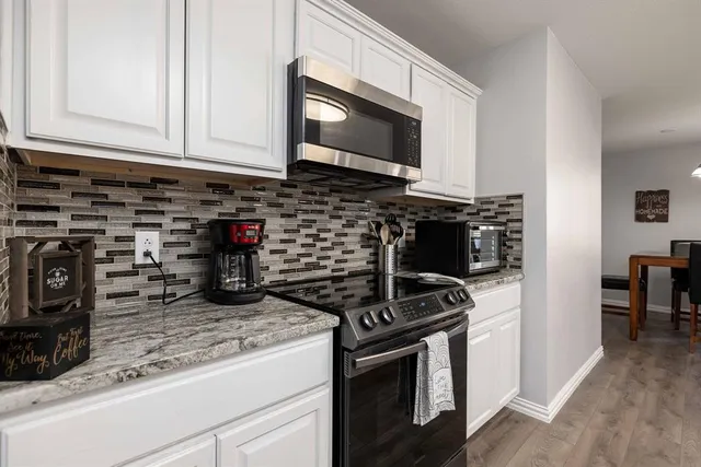 a kitchen with a refrigerator and a stove top oven
