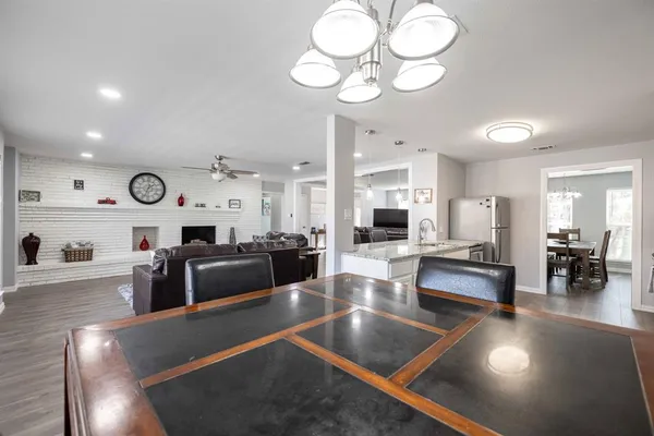 a kitchen with a sink dishwasher a dining table and chairs with wooden floor