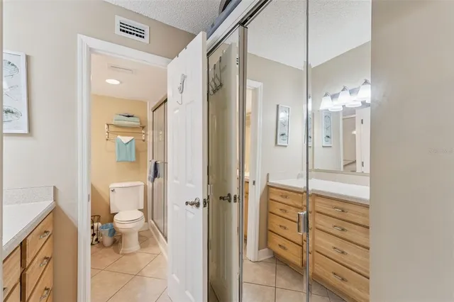 a bathroom with a sink a toilet a mirror and shower